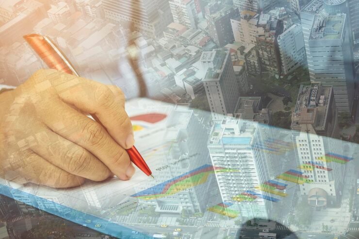 Digital composite businessman writing graph with cityscape